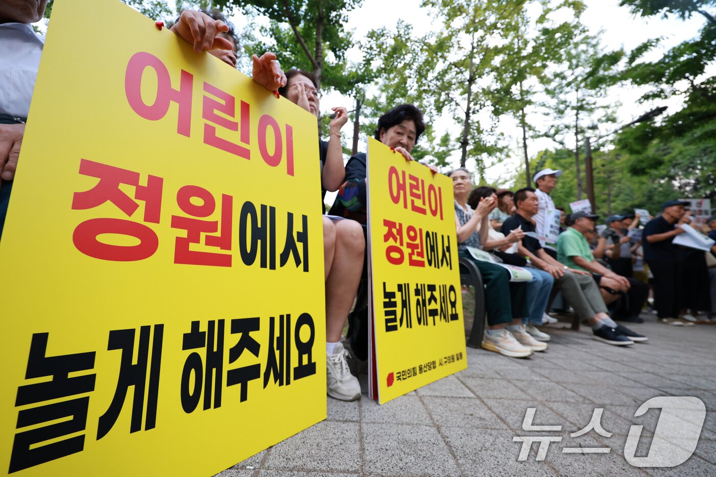 본문 이미지 - 용산 주민들이 19일 서울 용산구 한마음공원에서 열린 '용산어린이정원 사수 궐기대회‘에서 피켓을 들며 용산어린이정원 일대 주택 공급 개발을 반대하고 있다. 2026.8.19 ⓒ 뉴스1 이호윤 기자