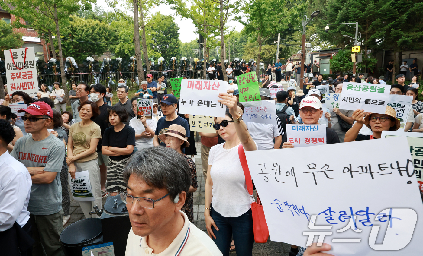 (서울=뉴스1) 이호윤 기자 = 용산 주민들이 19일 서울 용산구 한마음공원에서 열린 '용산어린이정원 사수 궐기대회‘에서 피켓을 들며 용산어린이정원 일대 주택 공급 개발을 반대하고 …