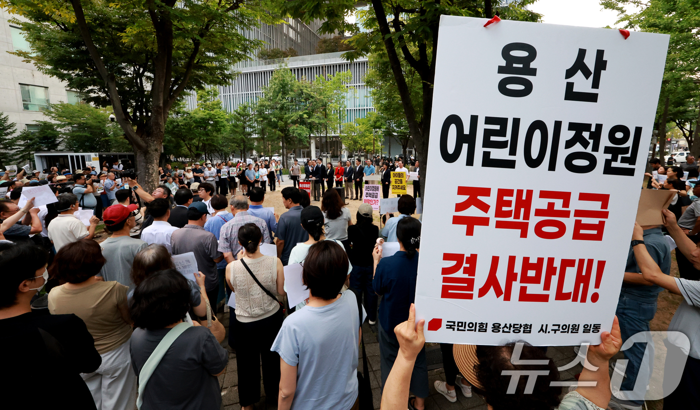 (서울=뉴스1) 이호윤 기자 = 용산 주민들이 19일 서울 용산구 한마음공원에서 열린 '용산어린이정원 사수 궐기대회‘에서 피켓을 들며 용산어린이정원 일대 주택 공급 개발을 반대하고 …