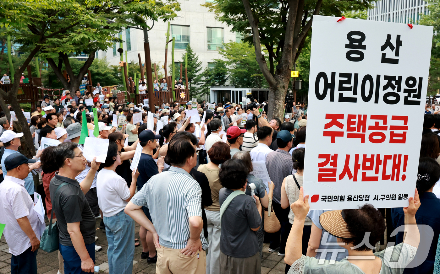 (서울=뉴스1) 이호윤 기자 = 용산 주민들이 19일 서울 용산구 한마음공원에서 열린 '용산어린이정원 사수 궐기대회‘에서 피켓을 들며 용산어린이정원 일대 주택 공급 개발을 반대하고 …