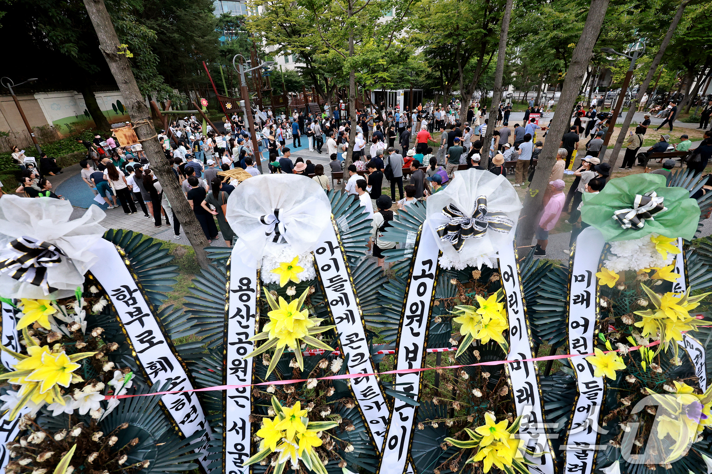 (서울=뉴스1) 이호윤 기자 = 용산 주민들이 19일 서울 용산구 한마음공원에서 열린 '용산어린이정원 사수 궐기대회‘에서 피켓을 들며 용산어린이정원 일대 주택 공급 개발을 반대하고 …