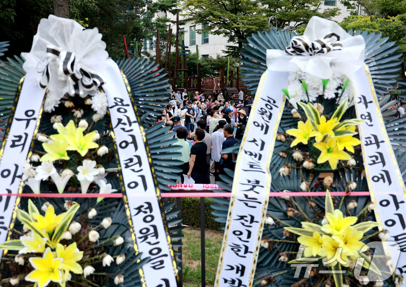 (서울=뉴스1) 이호윤 기자 = 용산 주민들이 19일 서울 용산구 한마음공원에서 열린 '용산어린이정원 사수 궐기대회‘에서 피켓을 들며 용산어린이정원 일대 주택 공급 개발을 반대하고 …