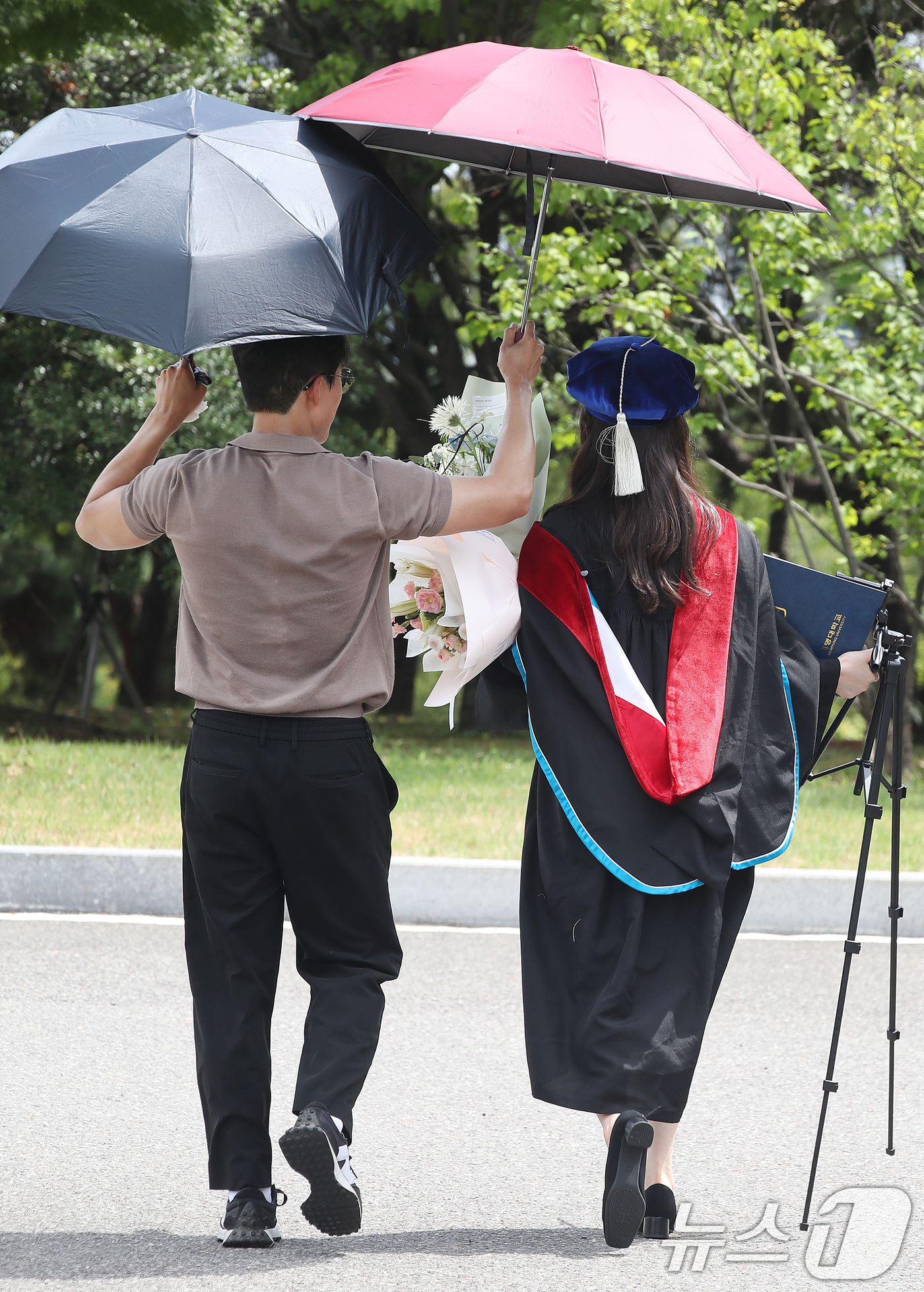 (대구=뉴스1) 공정식 기자 = 20일 대구 달서구 계명대학교 성서캠퍼스에서 '2025학년도 후기 학위수여식'을 마친 졸업생이 가족과 함께 양산으로 뙤약볕을 가린 채 기념사진을 찍 …