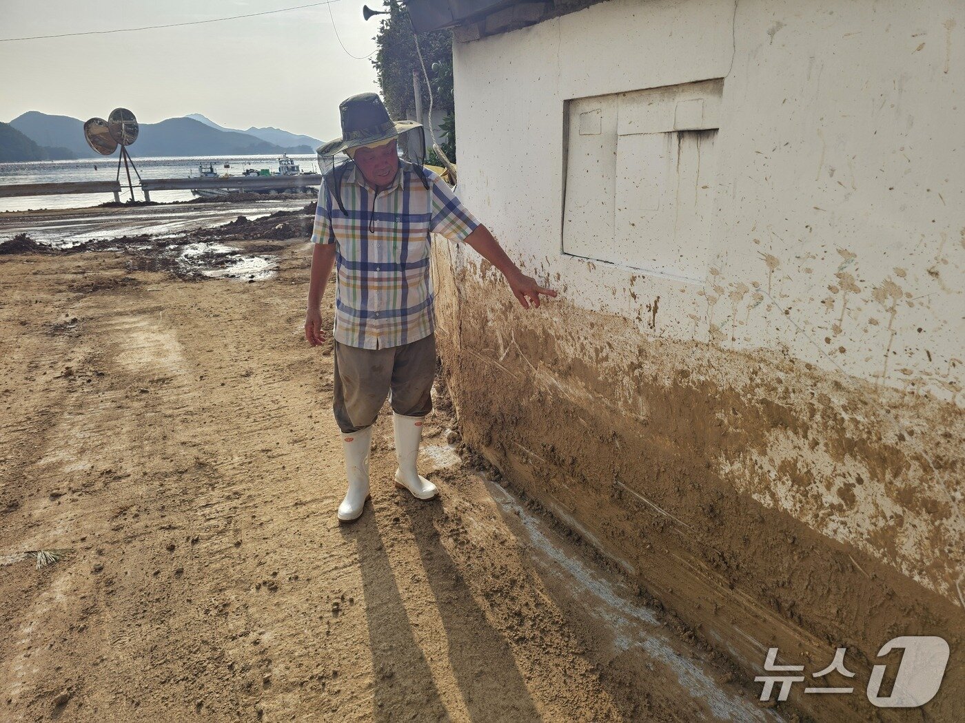 본문 이미지 - 어구마을 주민 문경붕 씨가 지난 17일 폭우 당시 물이 들어찬 높이를 설명하고 있다. 2026.8.20 ⓒ 뉴스1 박민석 기자