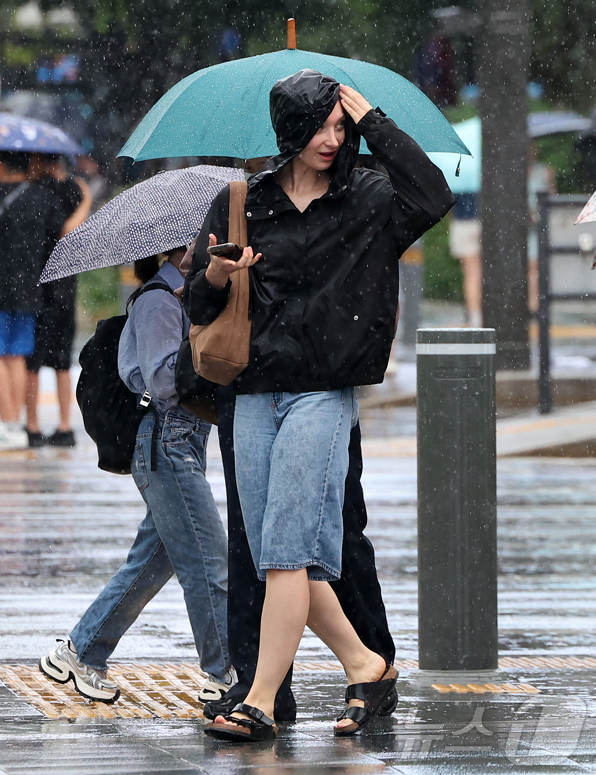 (서울=뉴스1) 김진환 기자 = 비가 내린 22일 오후 서울 종로구 광화문 사거리에서 외국인 관광객이 비를 피하며 횡단보도를 건너고 있다. 2026.8.22/뉴스1