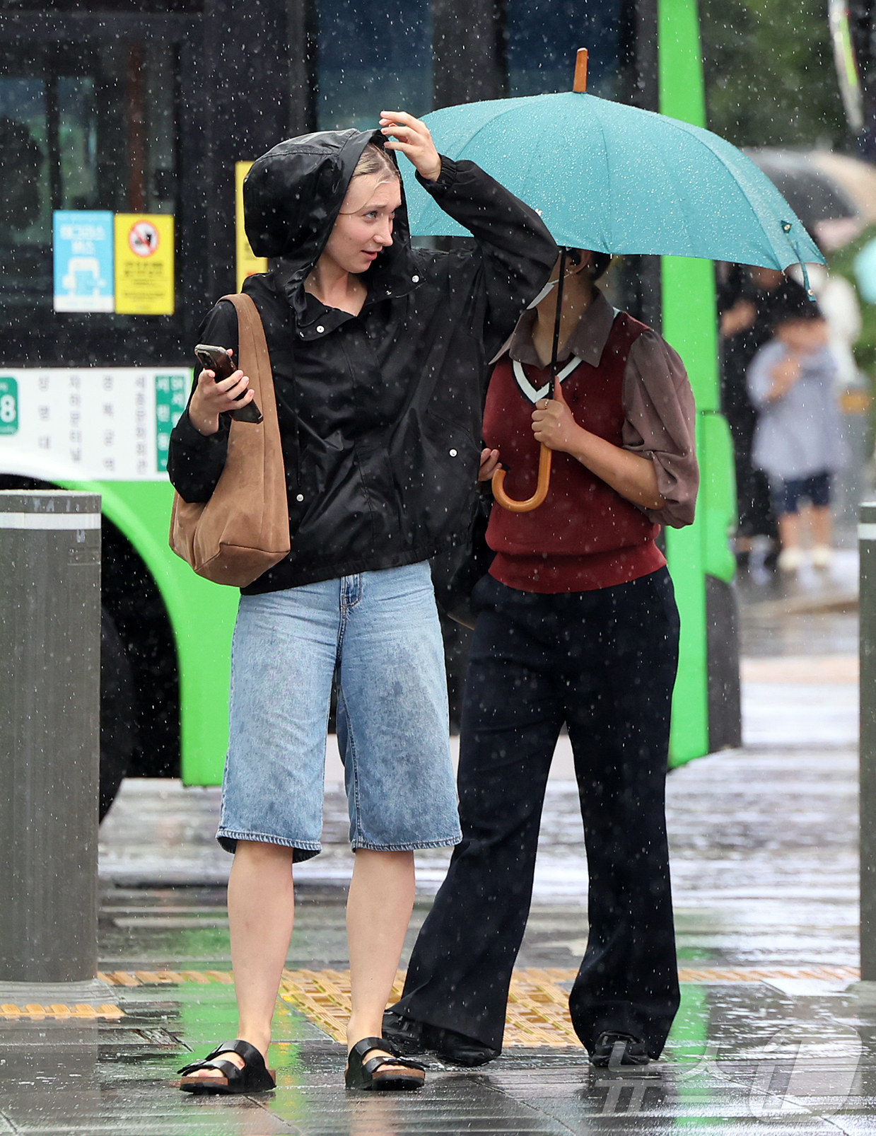 (서울=뉴스1) 김진환 기자 = 비가 내린 22일 오후 서울 종로구 광화문 사거리에서 외국인 관광객이 비를 피하며 횡단보도를 건너고 있다. 2026.8.22/뉴스1