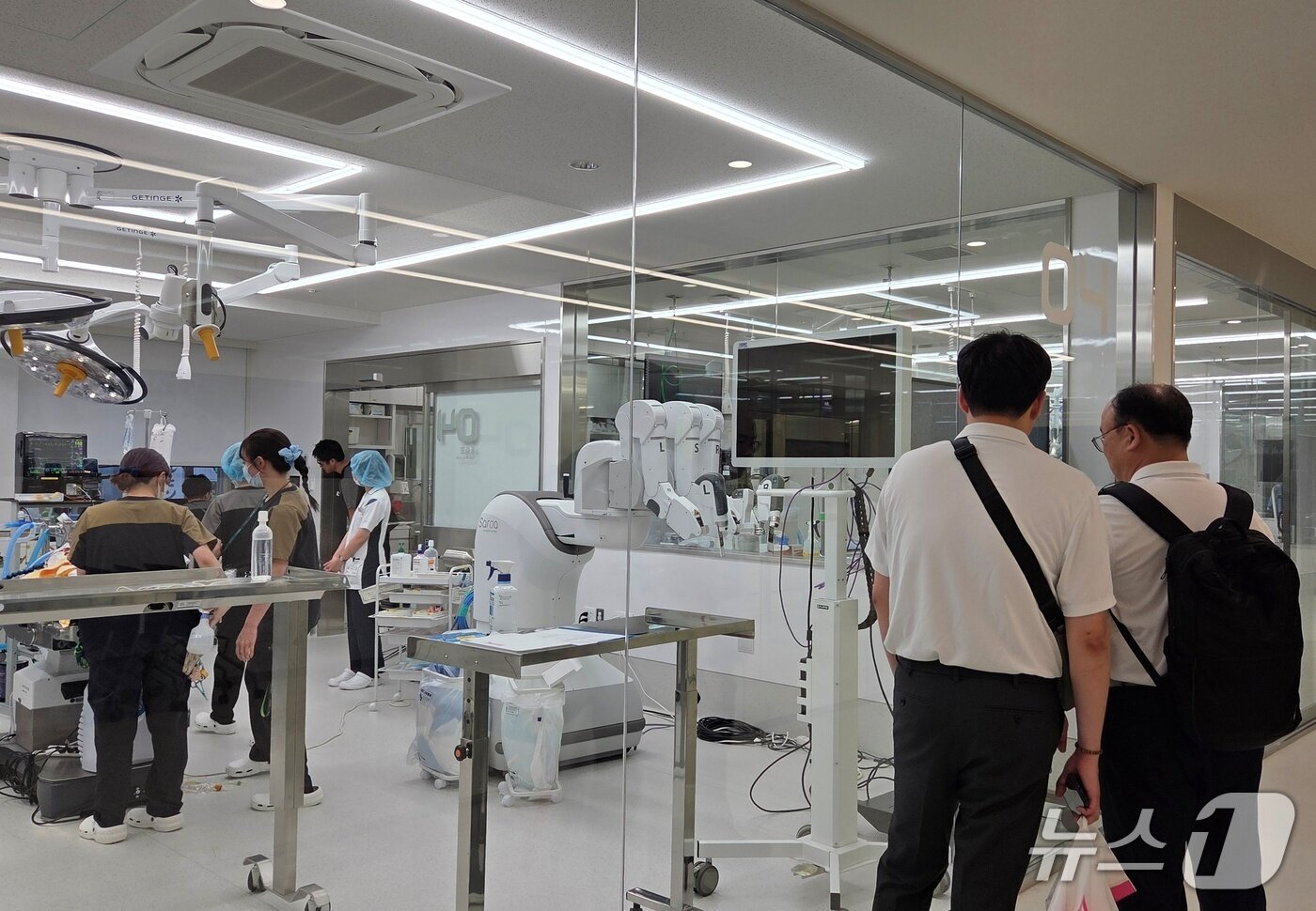 본문 이미지 - 오이세·문종선 스카이동물메디컬센터 원장이 22일 자비스 도쿄 동물병원에 설치된 로봇수술기를 보고 있다. ⓒ 뉴스1