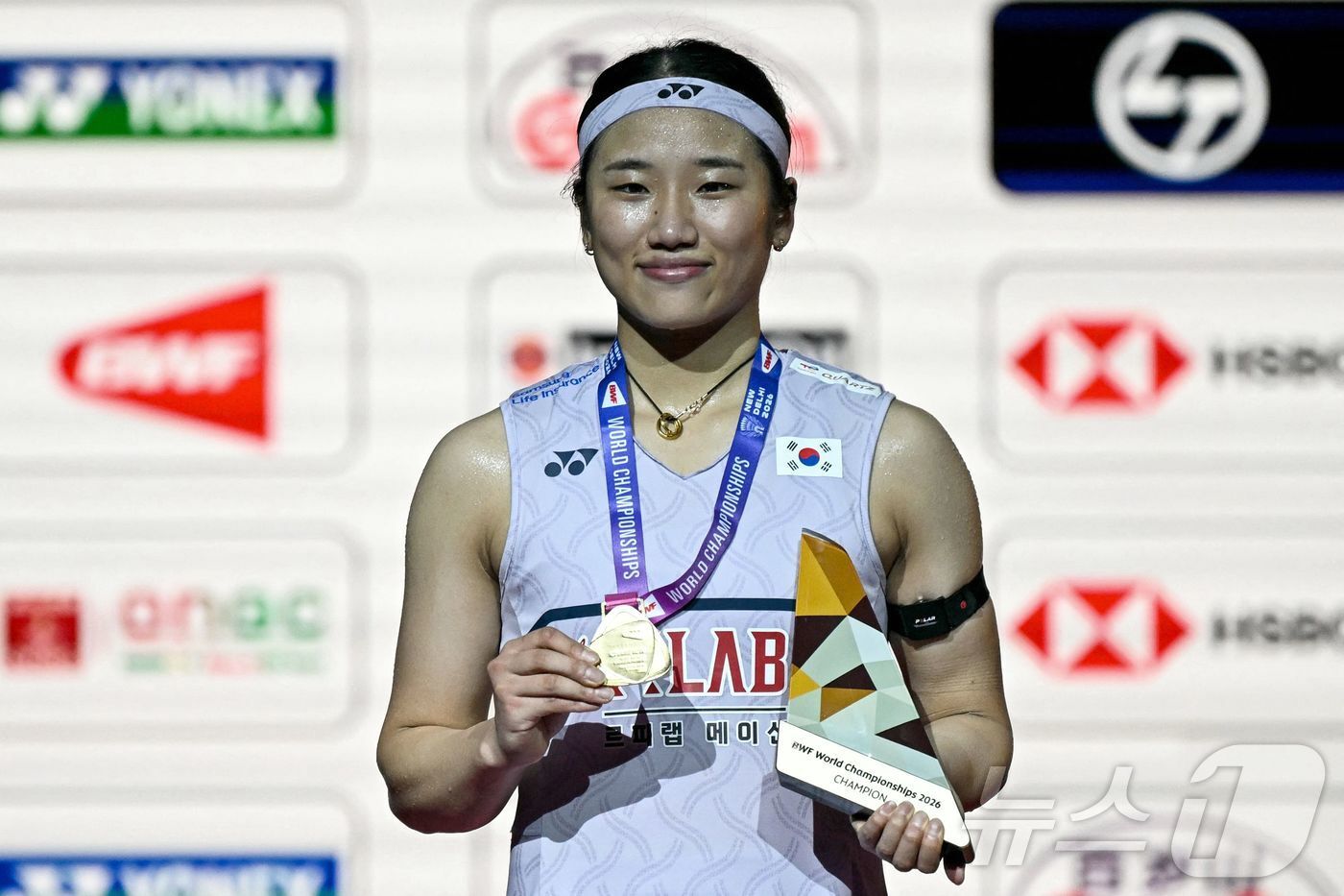 본문 이미지 - 배드민턴 여자 단식 세계랭킹 1위 안세영이 23일(한국시간) 인도 뉴델리에서 열린 2026 세계배드민턴연맹(BWF) 세계선수권대회 여자 단식 결승전 시상식에서 금메달을 목에 걸고 미소를 보이고 있다. ⓒ AFP=뉴스1