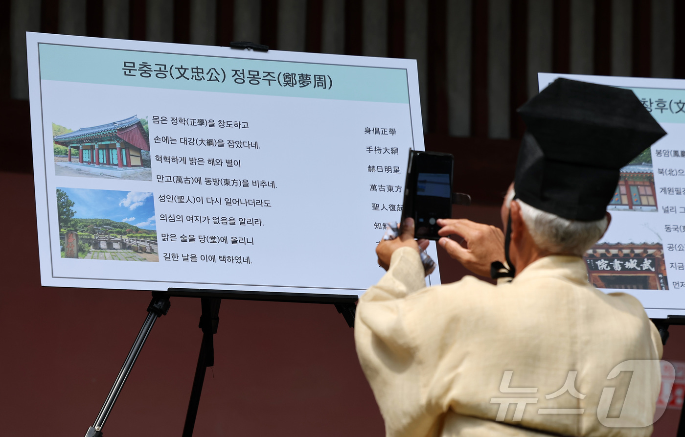 (서울=뉴스1) 김성진 기자 = 24일 서울 종로구 성균관 대성전에서 열린 '공기 2577년 성균관 대성전 준공식 및 위패 환안 행차'에서 한 유림이 사진 촬영을 하고 있다.대성전 …