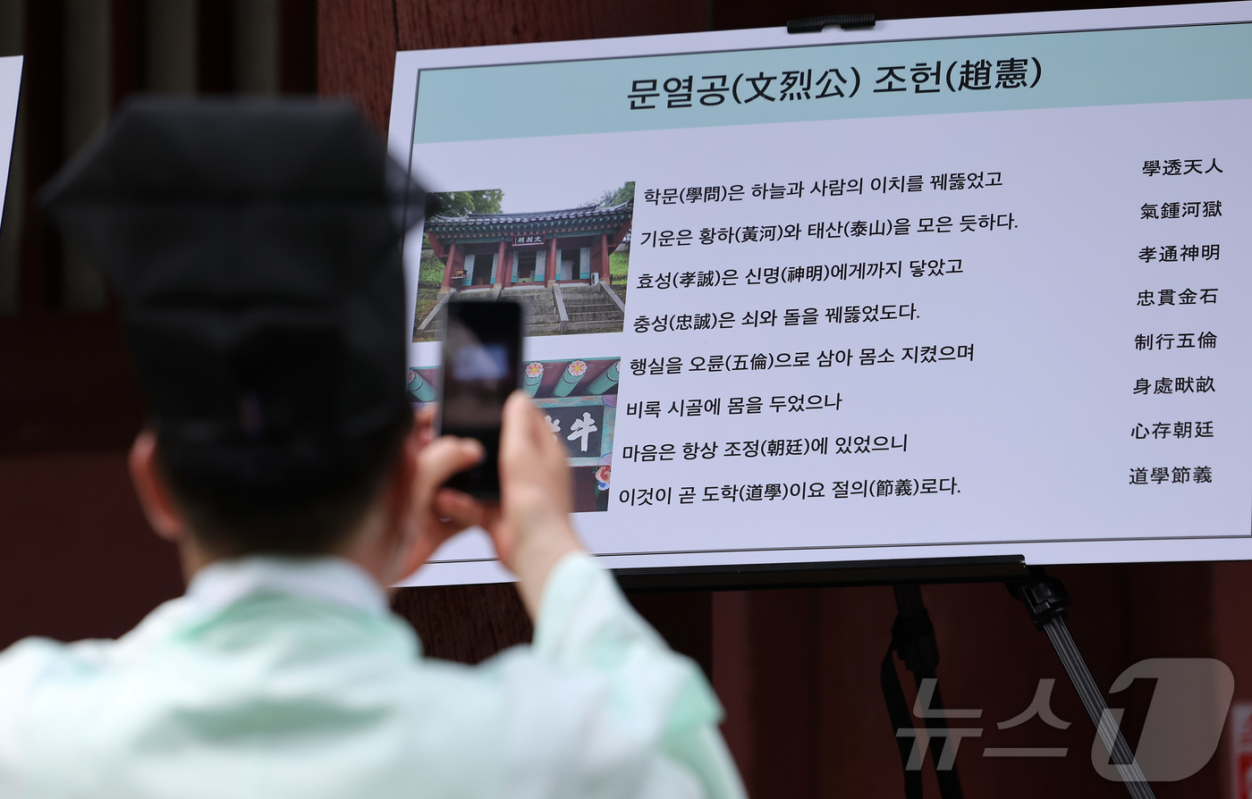 (서울=뉴스1) 김성진 기자 = 24일 서울 종로구 성균관 대성전에서 열린 '공기 2577년 성균관 대성전 준공식 및 위패 환안 행차'에서 한 유림이 사진 촬영을 하고 있다.대성전 …