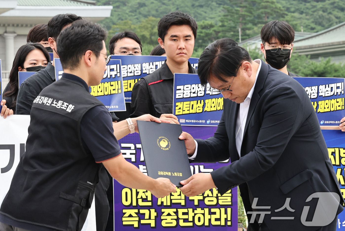 (서울=뉴스1) 이종수 기자 = 금융감독원과 예금보험공사 노동조합 관계자들이 24일 오전 서울 종로구 청와대 분수대 앞에서 금융감독기관 지방이전 반대 공동 기자회견을 한 뒤 청와대 …