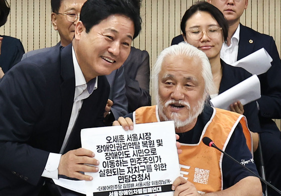 손 맞잡은 전장연·서울시의회 민주당