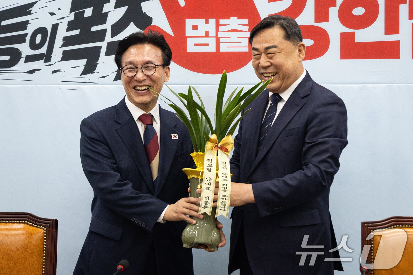 본문 이미지 - 김종훈 진보당 대표가 24일 서울 여의도 국회에서 김민석 더불어민주당 대표를 접견, 당대표 취임 축하난을 선물하고 있다. 2026.8.24 ⓒ 뉴스1 유승관 기자