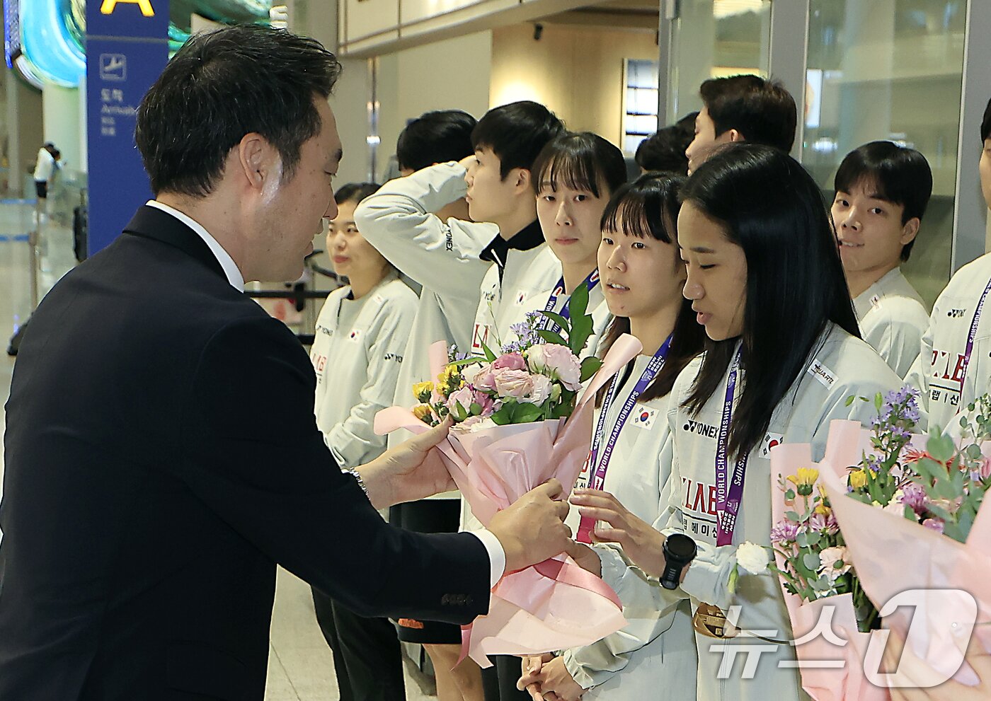 본문 이미지 - 김동문 대한배드민턴협회장이 25일 오전 인천국제공항을 통해 귀국한 2026 세계배드민턴연맹(BWF) 세계선수권대회 여자 단식 우승을 차지한 안세영에게 꽃다발을 전달하고 있다. 2026.8.25 ⓒ 뉴스1 박정호 기자