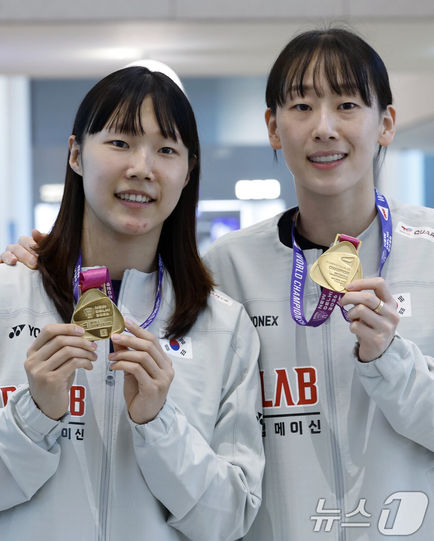 본문 이미지 - 세계선수권대회 여자복식 우승을 차지한 이소희(오른쪽)와 백하나가 25일 오전 인천국제공항을 통해 귀국해 메달을 들어 보이고 있다.  2026.8.25 ⓒ 뉴스1 박정호 기자