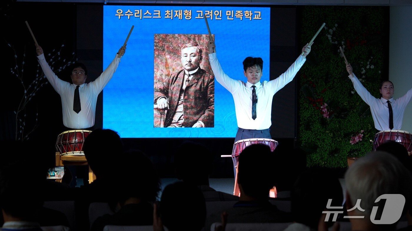 본문 이미지 -  러시아 우수리스크 최재형 고려인 민족학교 학생들이 최재형 선생의 사진을 배경으로 경기교육청 역사탐방단에게 북 공연을 선보이고 있다. (황현필 소장 제공) 
