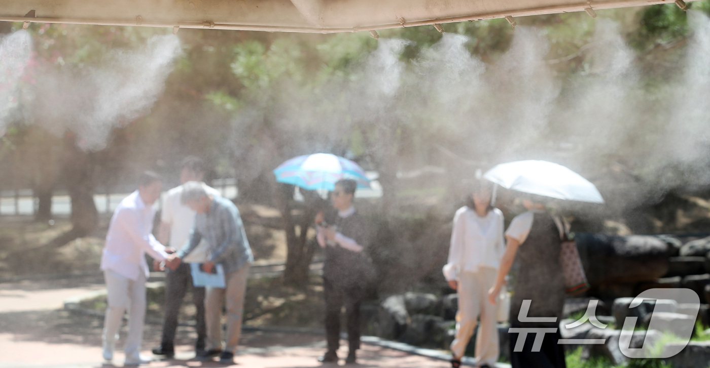 (대구=뉴스1) 공정식 기자 = 폭염특보가 발효된 25일 대구 수성구 수성못 상화동산에서 시민들이 뙤약볕을 피해 쿨링포그(안개형 냉각 장치) 주변을 지나고 있다. 2026.8.25 …