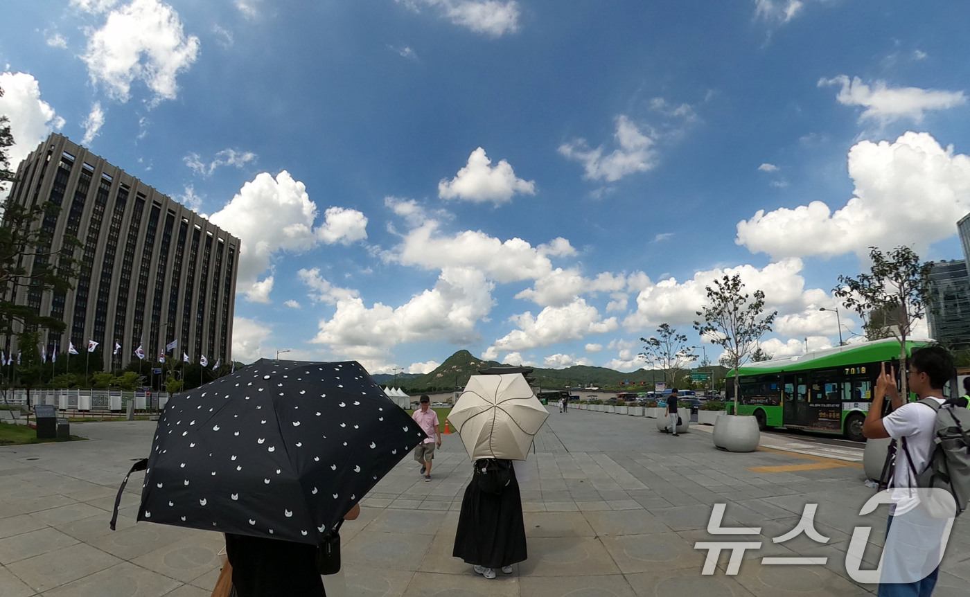 (서울=뉴스1) 김명섭 기자 = 25일 서울 종로구 광화문광장에서 관광객들이 양산을 쓰고 이동하고 있다. 이날 전국 대부분 지역에서 무더위가 이어져 낮 최고기온은 36도까지 오르고 …