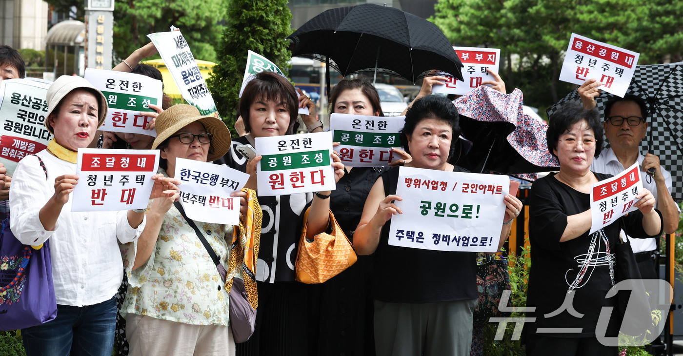 (서울=뉴스1) 이종수 기자 = 25일 서울시의회 정문 앞에서 열린 12대 서울시의회 국민의힘 긴급 결의문 발표 기자회견에서 참석자들이 용산공원 개발과 관련된 피켓을 들고 있다. …