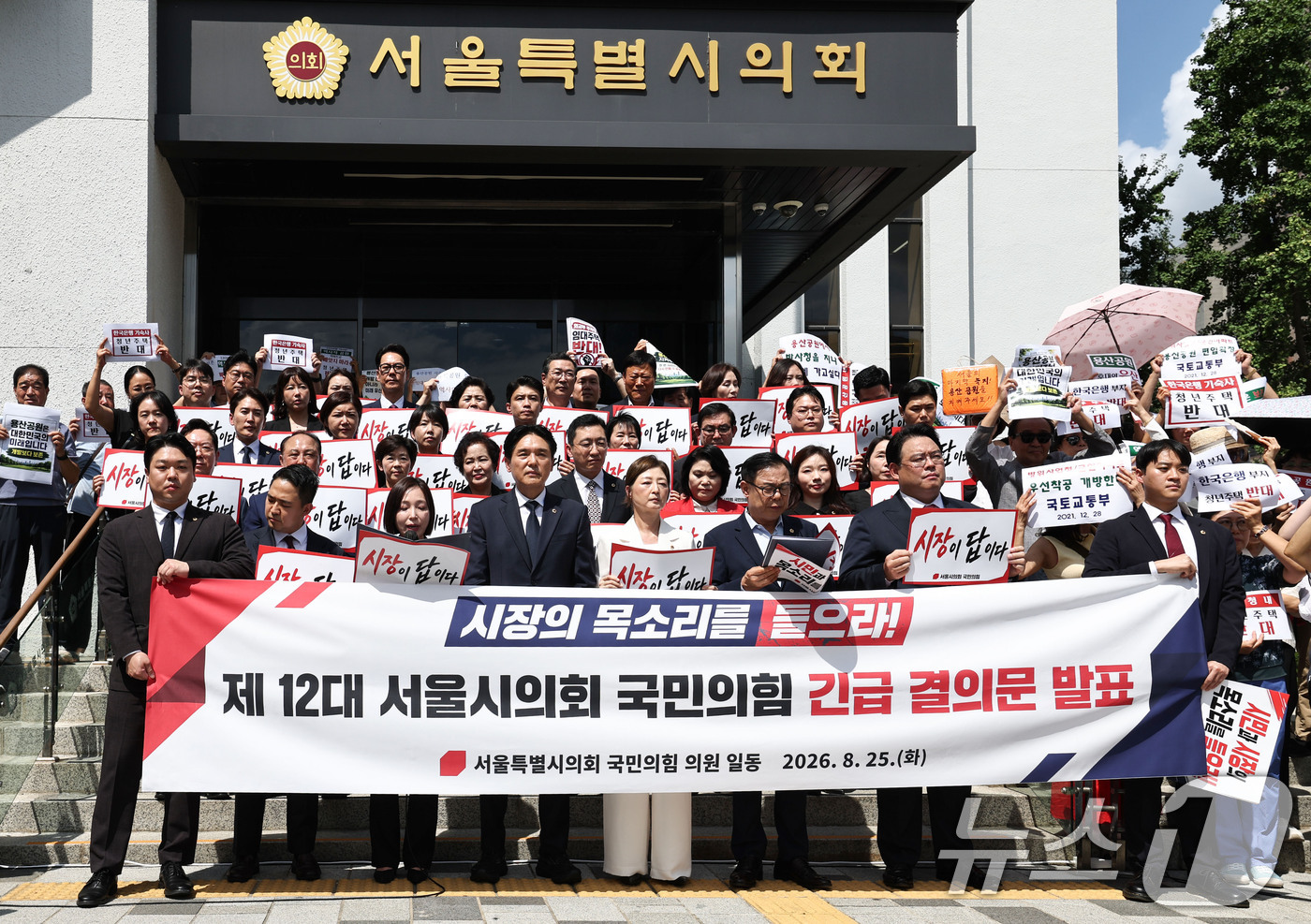 (서울=뉴스1) 이종수 기자 = 25일 서울시의회 정문 앞에서 열린 12대 서울시의회 국민의힘 긴급 결의문 발표 기자회견에서 참석자들이 용산공원 개발과 관련된 피켓을 들고 있다. …