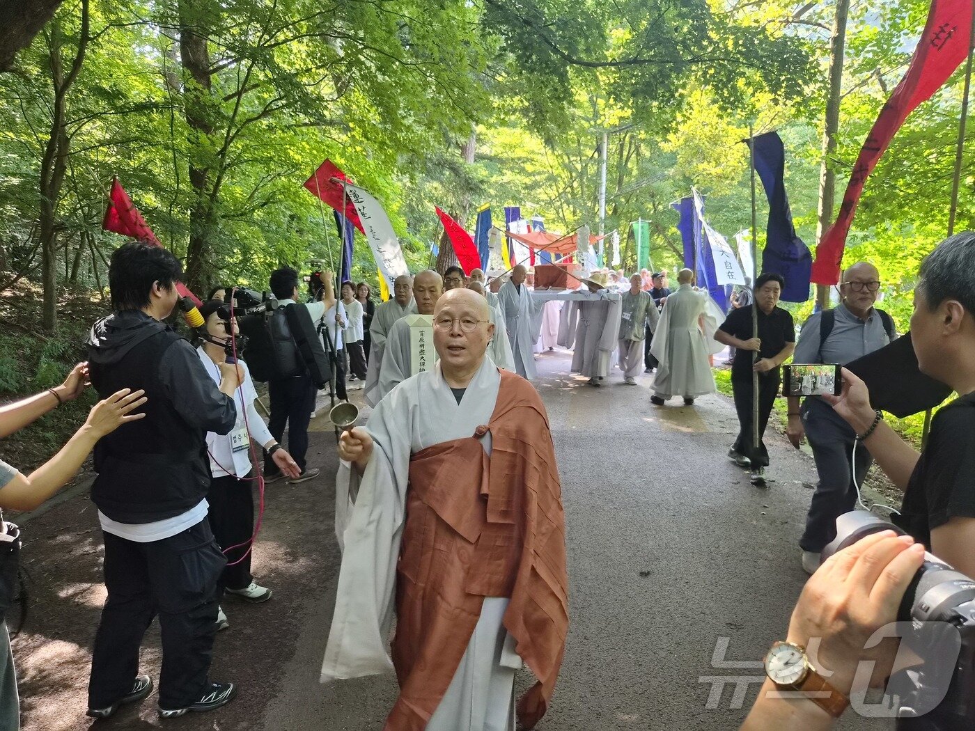 본문 이미지 - 만장기를 든 사부대중들의 행렬과 고 명진 스님의 법구가 25일 법주사 다비장으로 이운되고 있다. 2026.8.25 ⓒ 뉴스1 임양규 기자