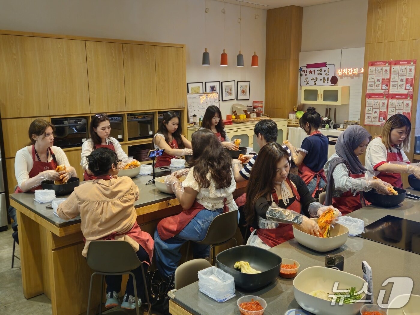 본문 이미지 - 배추에 김치 양념을 버무리고 있는 글로벌 캠프 참가자들 ⓒ 뉴스1 박혜연 기자