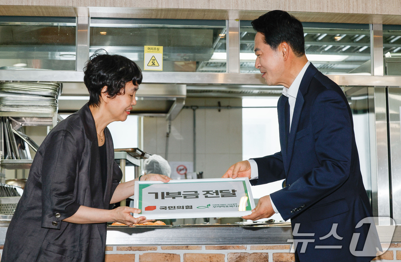 (서울=뉴스1) 박지혜 기자 = 장동혁 국민의힘 대표(오른쪽)가 26일 서울 마포구 우리마포복지관에서 배식 봉사활동에 앞서 복지관 측에 기부금을 전달하고 있다. (공동취재) 202 …