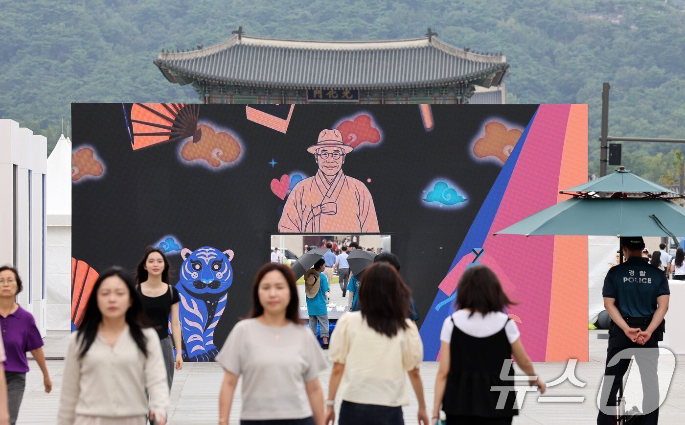 본문 이미지 - 26일 서울 종로구 광화문 광장에서 관광객들이 ‘김구 탄생 150주년' 미디어 게이트를 통과하고 있다. 국가보훈부(장관 권오을)는 광복회(회장 이종찬)와 함께 '김구 탄생 150주년 유네스코 기념해'를 맞아 30일까지 서울 광화문광장에서 국민 참여형 ‘김구 문화주간’ 행사를 개최한다고 밝혔다. 2026.8.26 ⓒ 뉴스1 이종덕 기자