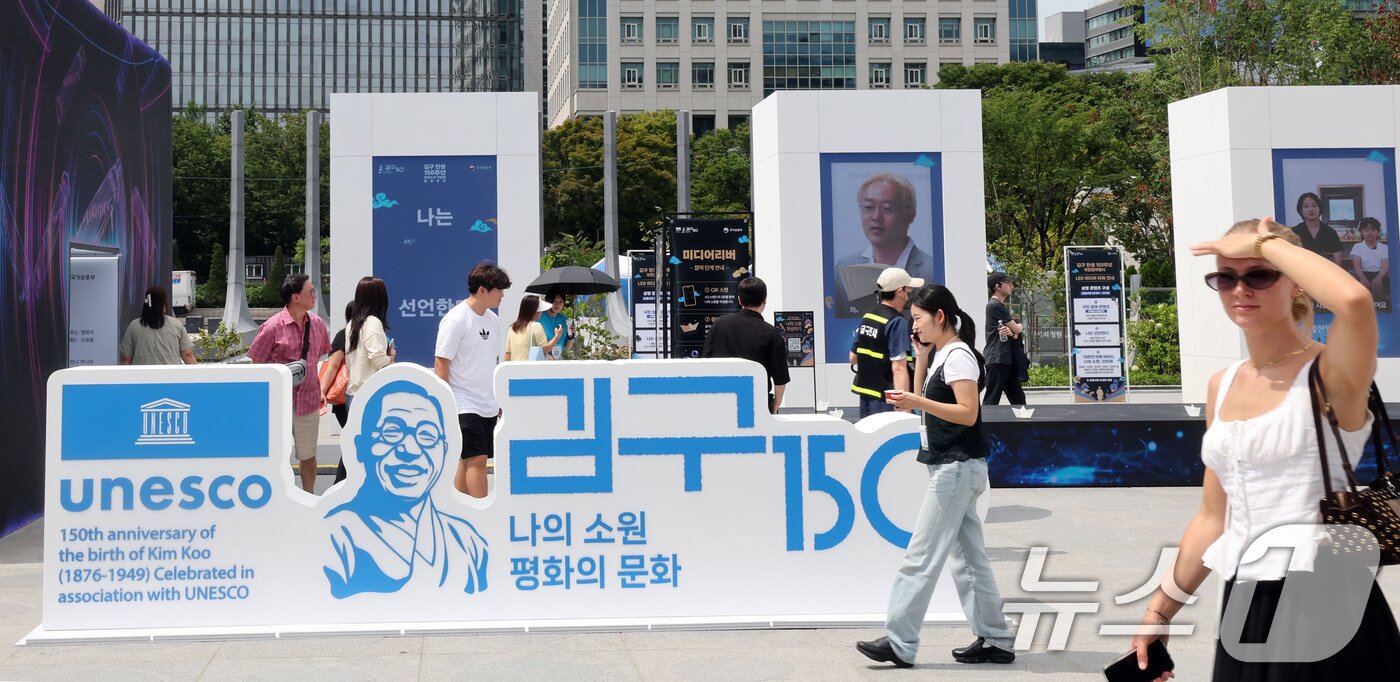 본문 이미지 - 26일 서울 종로구 광화문 광장에서 관광객들이 ‘김구 탄생 150주년 조형물’을 살펴보고 있다. 2026.8.26 ⓒ 뉴스1 이종덕 기자