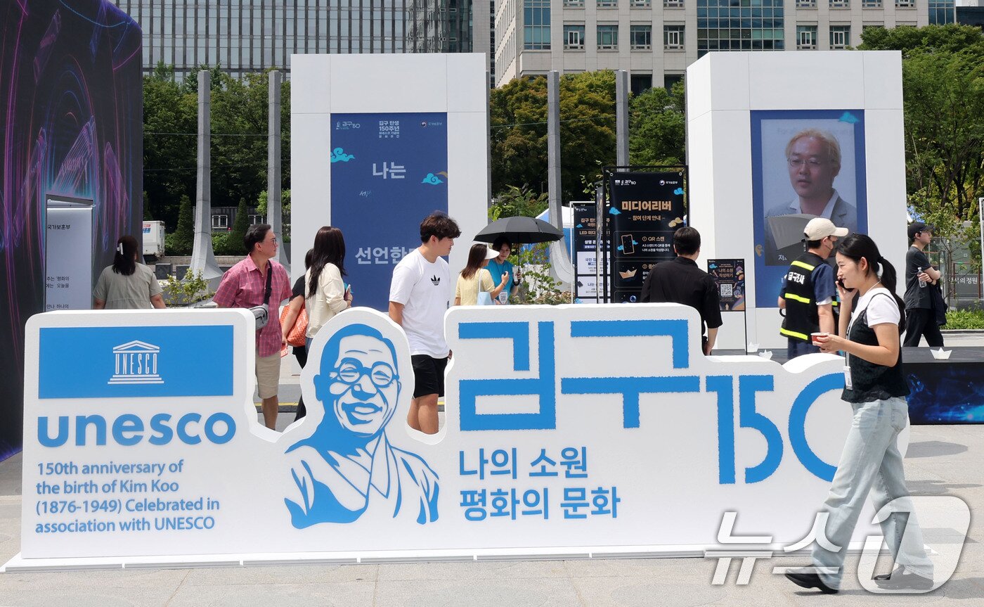 본문 이미지 - 26일 서울 종로구 광화문 광장에서 관광객들이 ‘김구 탄생 150주년 조형물’을 살펴보고 있다. 2026.8.26 ⓒ 뉴스1 이종덕 기자