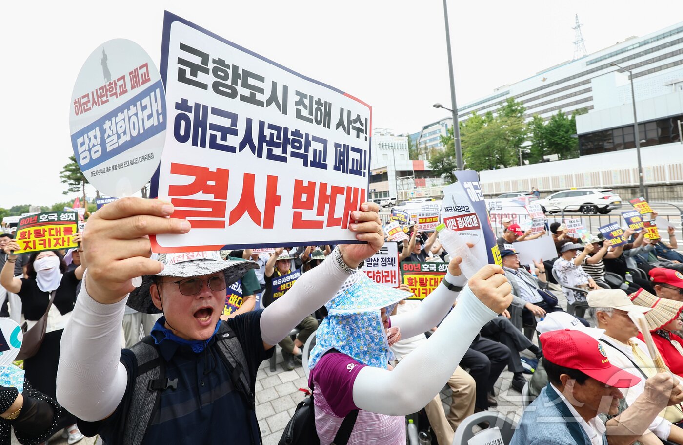 본문 이미지 - 육·해·공 사관학교 통합형인 '국군사관학교' 창설 관련 공청회가 열린 26일 오후 서울 용산구 전쟁기념관 앞에서 열린 육·해·공 사관학교 통폐합 반대 집회에서 참석자들이 사관학교 통폐합에 반대하는 손팻말을 들고 구호를 외치고 있다. 2026.8.26 ⓒ 뉴스1 김민지 기자