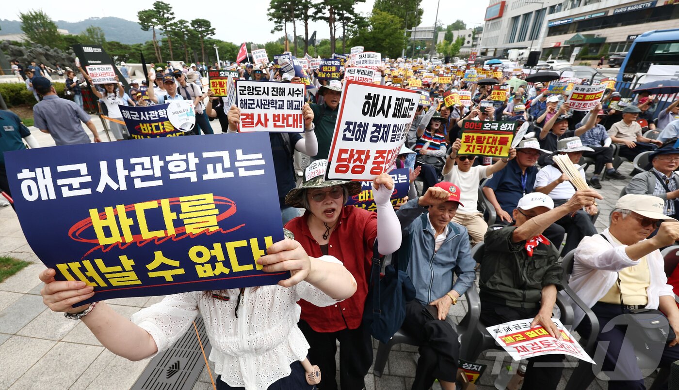 본문 이미지 - 육·해·공 사관학교 통합형인 '국군사관학교' 창설 관련 공청회가 열린 26일 오후 서울 용산구 전쟁기념관 앞에서 열린 육·해·공 사관학교 통폐합 반대 집회에서 참석자들이 사관학교 통폐합에 반대하는 손팻말을 들고 구호를 외치고 있다. 2026.8.26 ⓒ 뉴스1 김민지 기자