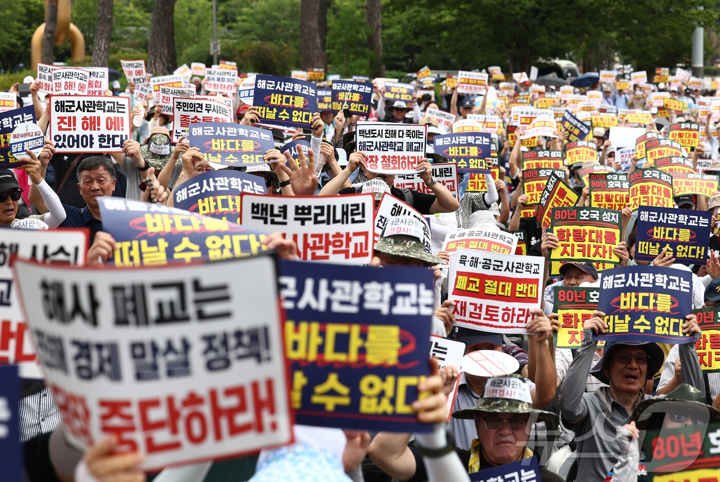 본문 이미지 - 육·해·공 사관학교 통합형인 '국군사관학교' 창설 관련 공청회가 열린 26일 오후 서울 용산구 전쟁기념관 앞에서 열린 육·해·공 사관학교 통폐합 반대 집회에서 참석자들이 사관학교 통폐합에 반대하는 손팻말을 들고 구호를 외치고 있다. 2026.8.26 ⓒ 뉴스1 김민지 기자