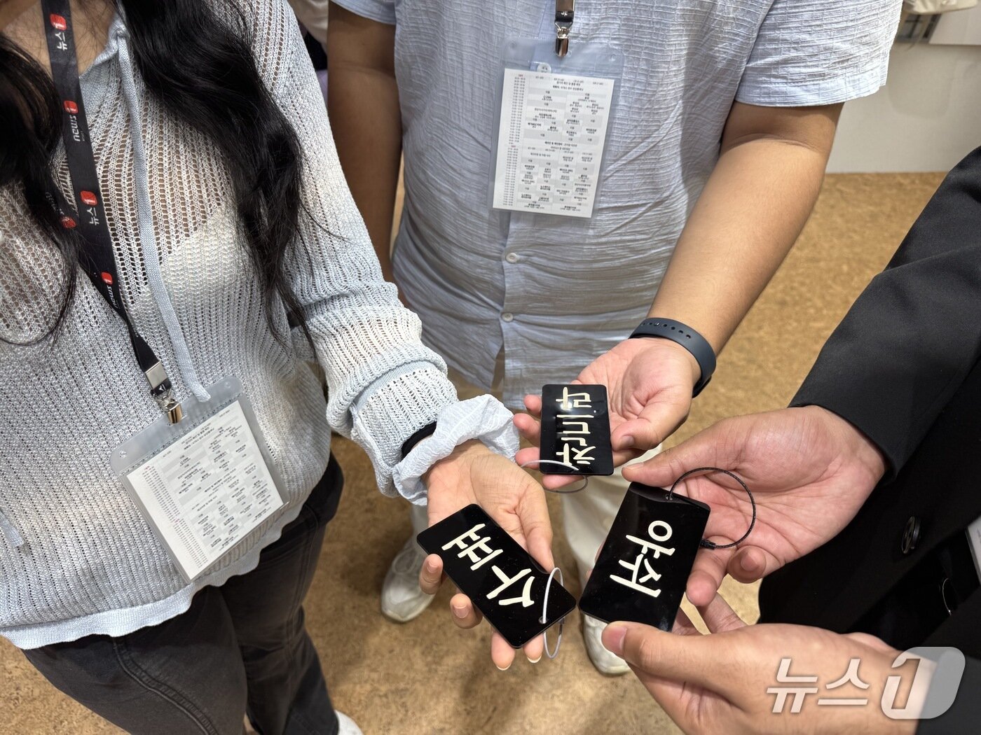 본문 이미지 - 26일 '뉴스1 K-브랜드 글로벌 캠프' 참가자들이 노스페이스 화이트라벨 명동 라운지에서 받은 이름 키링을 찍고 있다. ⓒ 뉴스1 황두현 기자