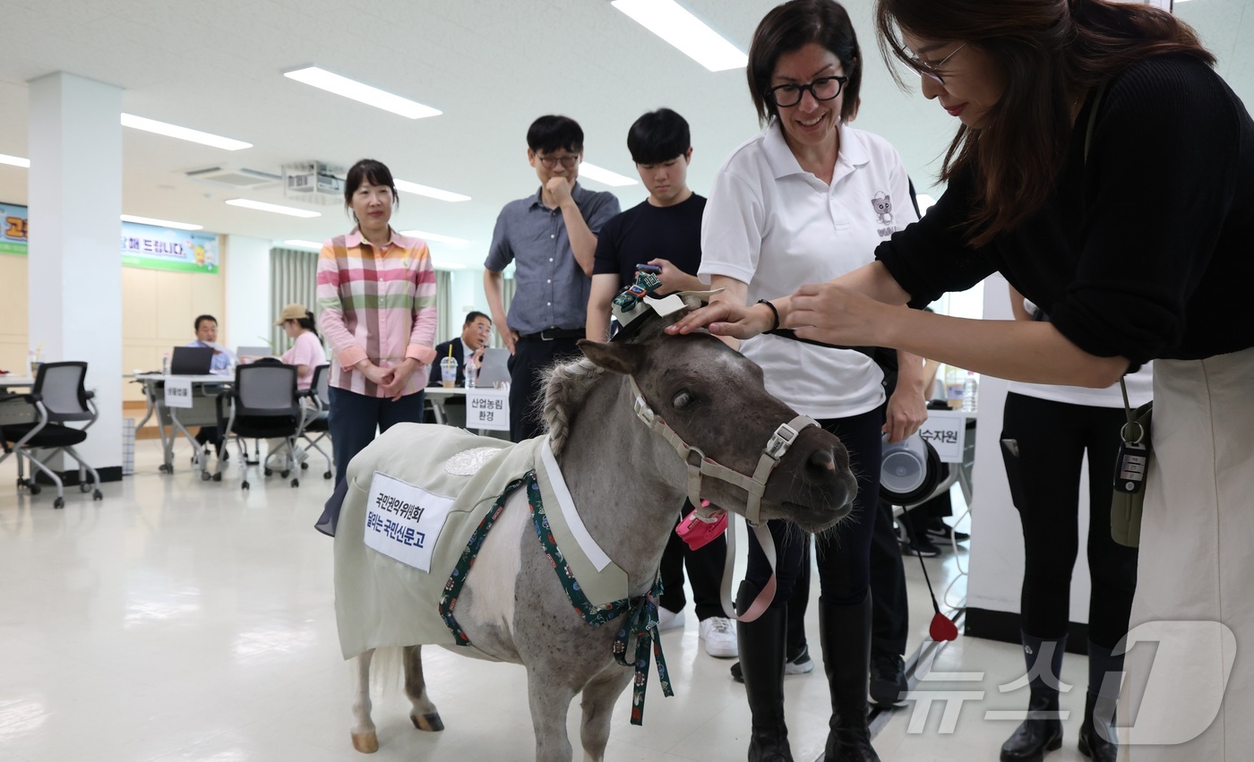 (시흥=뉴스1) 김기남 기자 = 국민권익위원회의 \'달리는 국민신문고\'가 27일 찾아간 경기 시흥시 연성동 행정복지센터의 고충 상담 현장에서 민원인들이 귀엽고 친근한 초소형마 \ …