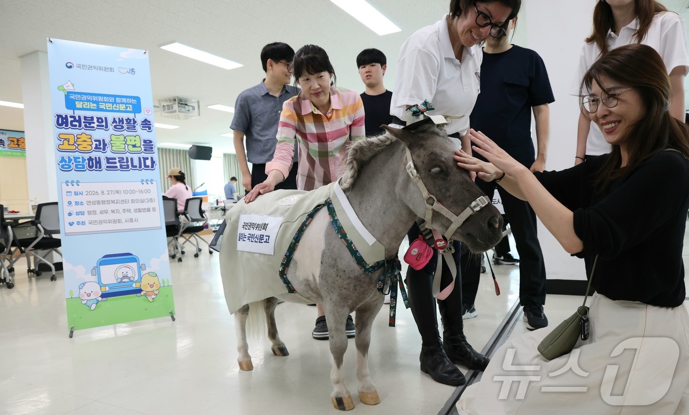 (시흥=뉴스1) 김기남 기자 = 국민권익위원회의 \'달리는 국민신문고\'가 27일 찾아간 경기 시흥시 연성동 행정복지센터의 고충 상담 현장에서 민원인들이 귀엽고 친근한 초소형마 \ …