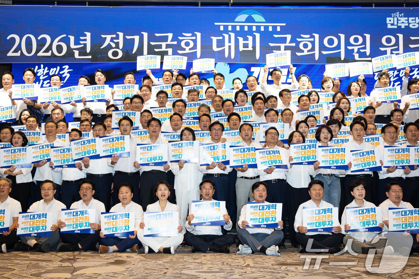 본문 이미지 - 김민석 더불어민주당 대표를 비롯한 의원들이 27일 인천 영종구 인스파이어 엔터테인먼트 리조트에서 열린 2026년 정기국회 대비 국회의원 워크숍에서 손팻말을 들고 구호를 외치고 있다. 2026.8.27 ⓒ 뉴스1 유승관 기자