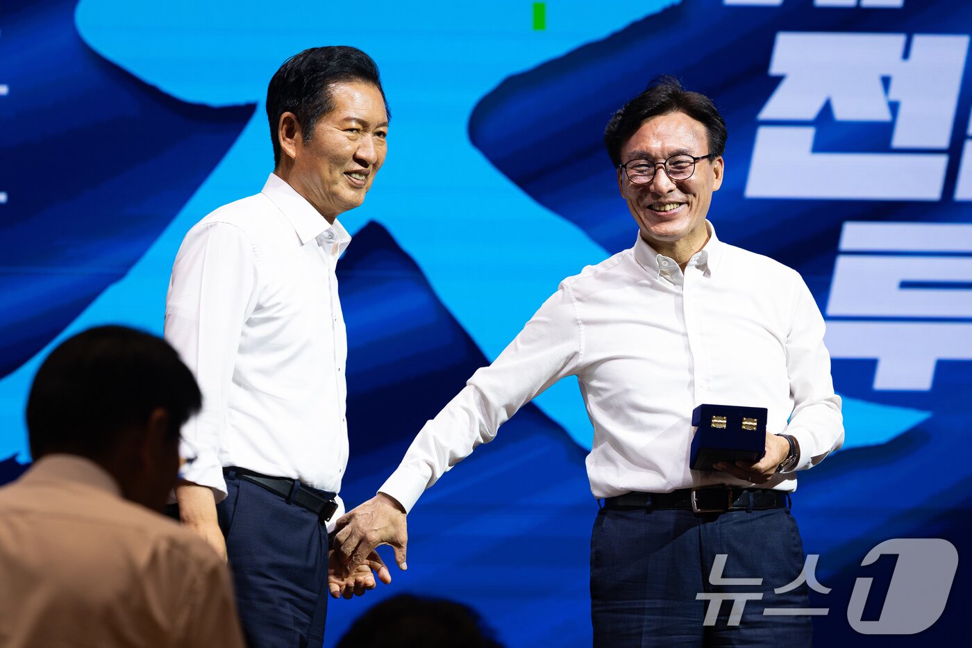 본문 이미지 - 김민석 더불어민주당 대표가 지난 8월 27일 인천 영종구 인스파이어 엔터테인먼트 리조트에서 열린 2026년 정기국회 대비 국회의원 워크숍에서 정청래 전 대표에게 감사패 전달에 앞서 손을 잡고 있다. 2026.8.27 ⓒ 뉴스1 유승관 기자