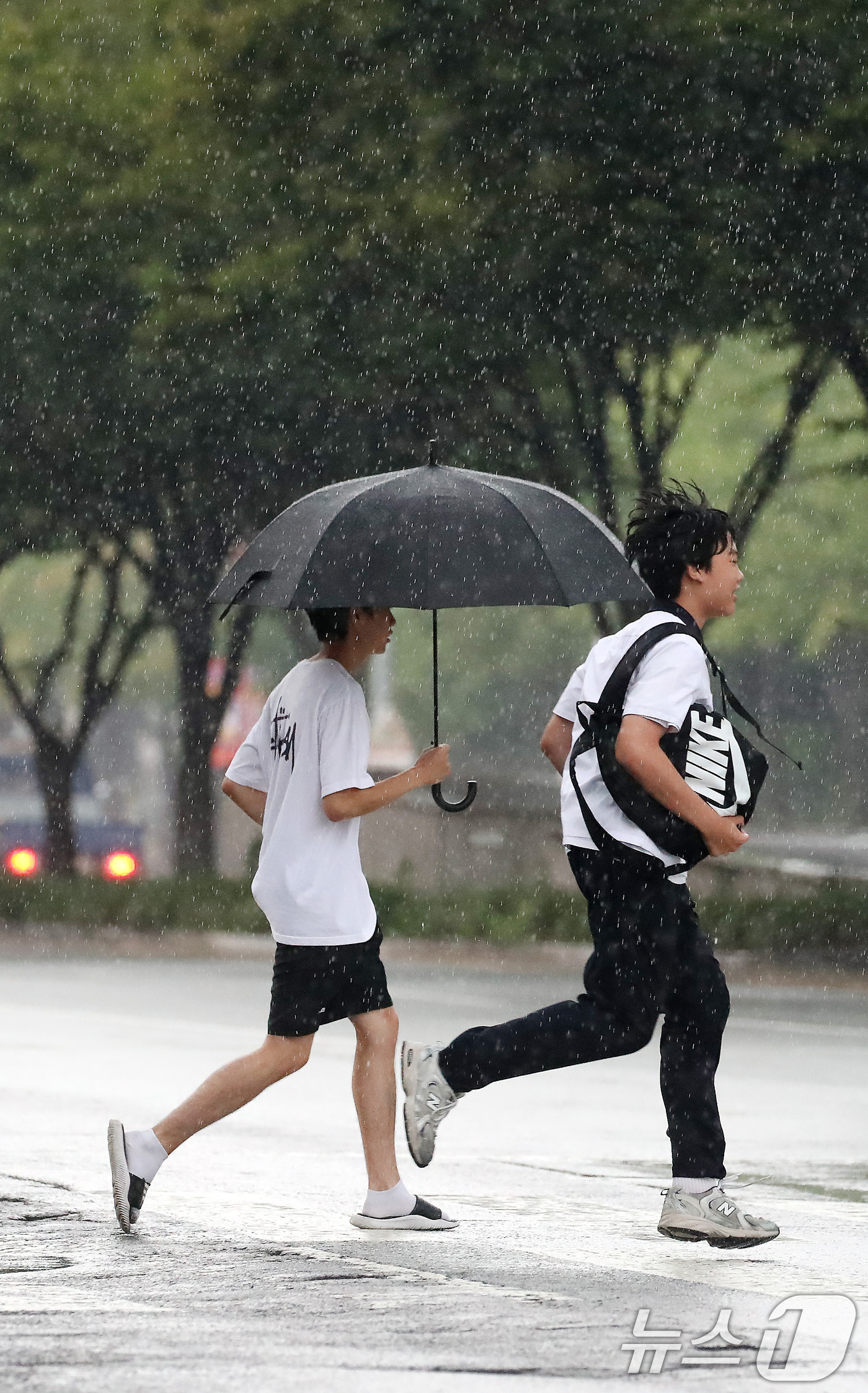 (대구=뉴스1) 공정식 기자 = 27일 오후 대구 수성구 달구벌대로 담티고개 인근에 천둥번개를 동반한 비가 내리자 하굣길 학생들이 발걸음을 재촉하고 있다. 2026.8.27/뉴스1 …