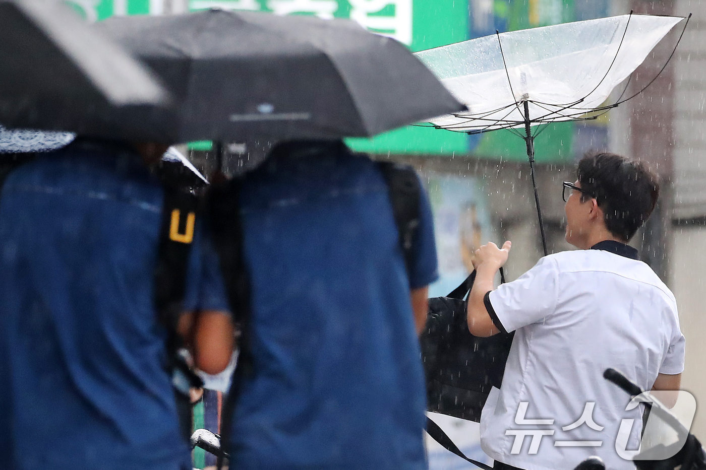 (대구=뉴스1) 공정식 기자 = 27일 오후 대구 수성구 달구벌대로 담티고개 인근에 천둥번개를 동반한 비가 내리자 하굣길 한 학생이 뒤집힌 우산을 펴고 있다. 2026.8.27/뉴 …