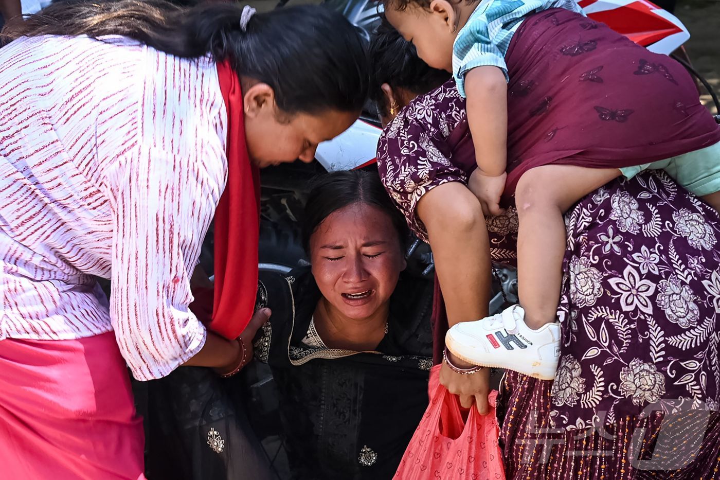 (누와코트 AFP=뉴스1) 최종일 선임기자 = 27일 네팔 누와코트 지역 바타르 바자르의 군부대에서 한 여성이 돌발 홍수 피해 지역에서 구조된 뒤 친척들이 도착하기를 기다리다 오열 …
