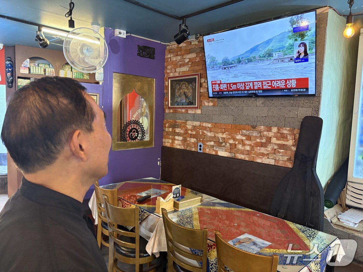 본문 이미지 - 서울 종로구 네팔거리에서 식당을 운영 중인 아구릉 리스만 씨가 28일 네팔 대홍수 관련 뉴스를 보고 있는 모습. 2026.8.28 ⓒ 뉴스1 안소연 수습기자