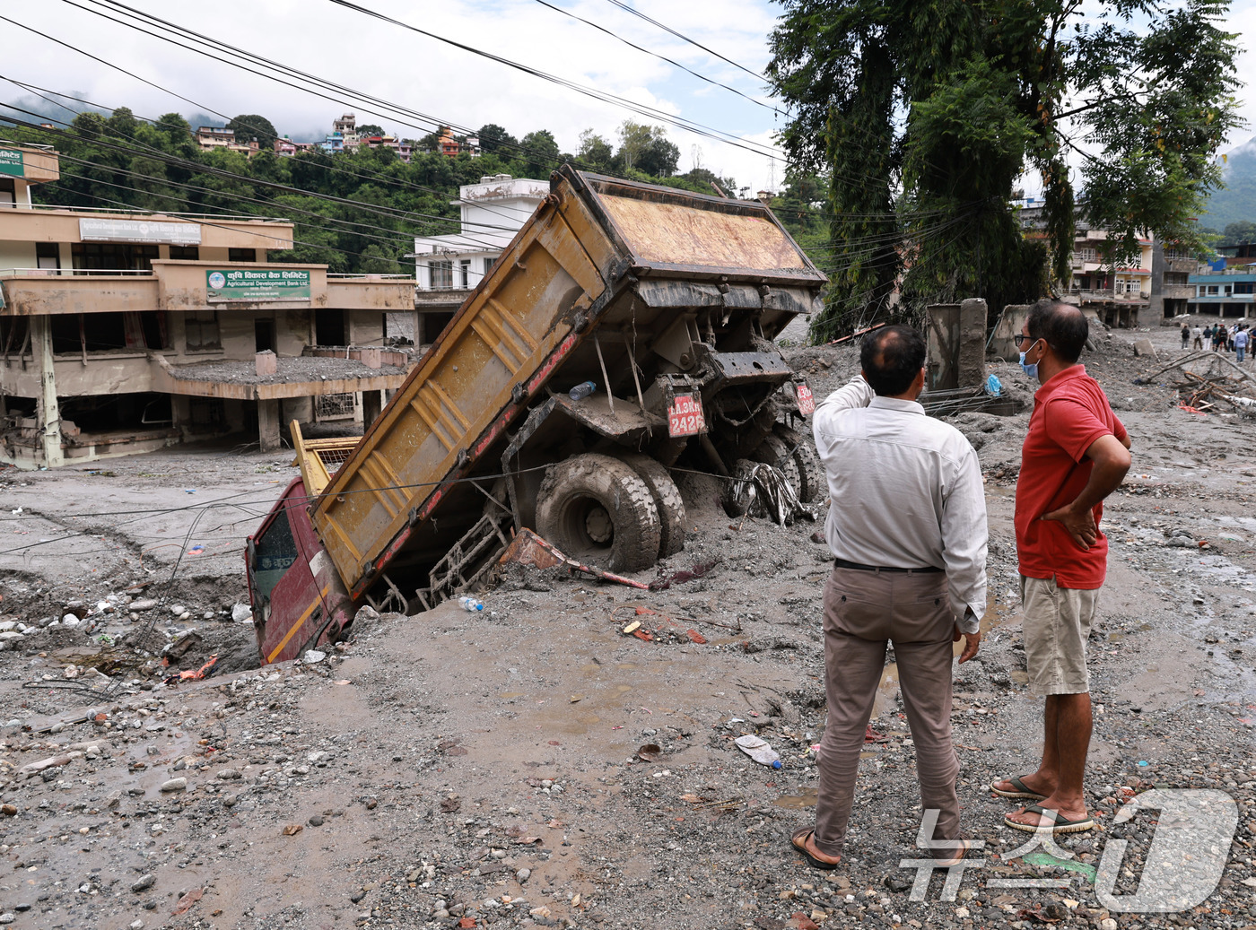 (비두르=뉴스1) 구윤성 기자 = 네팔 대홍수 나흘째인 29일 오전(현지시간) 수해를 입은 네팔 중북부 비두르 시내에서 덤프트럭이 토사에 처박혀 있다. 2026.8.29/뉴스1