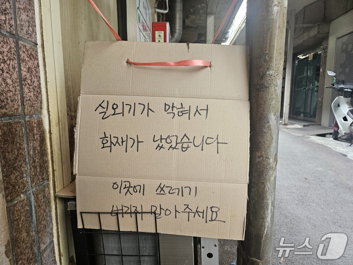 본문 이미지 - 서울 중구 한 골목의 에어컨 실외기에 쓰레기 투기를 금지하는 안내문이 붙어있는 모습. 2026.7.27 ⓒ 뉴스1 유채연 기자