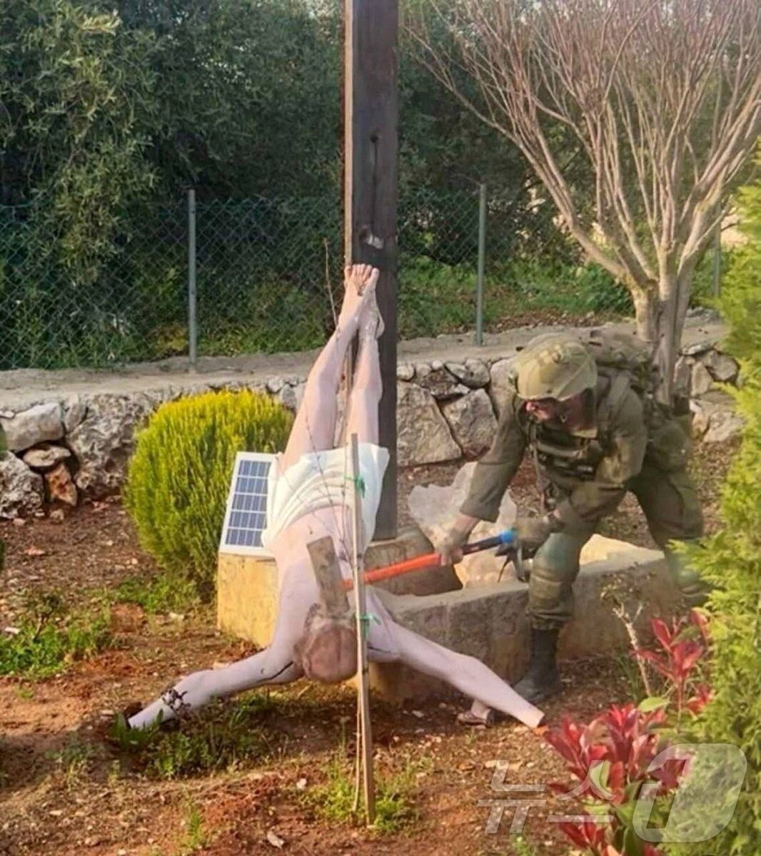 본문 이미지 - 지난 4월 이스라엘군 병사가 레바논 데벨에서 예수 그리스도상을 망치로 내려치는 모습. 사진은 소셜미디어 영상 갈무리. 2026.04.19 ⓒ 로이터=뉴스1