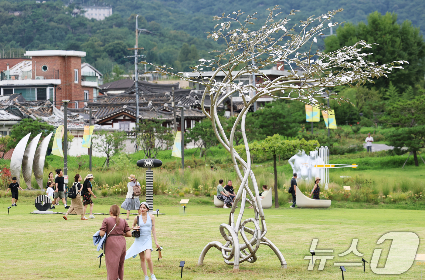 (서울=뉴스1) 오대일 기자 = 30일 오후 서울 종로구 열린송현녹지광장을 찾은 시민들이 제3회 서울조각페스티벌 전시작을 감상하고 있다.‘예술의 도시, 산들바람 타고’를 주제로 열 …