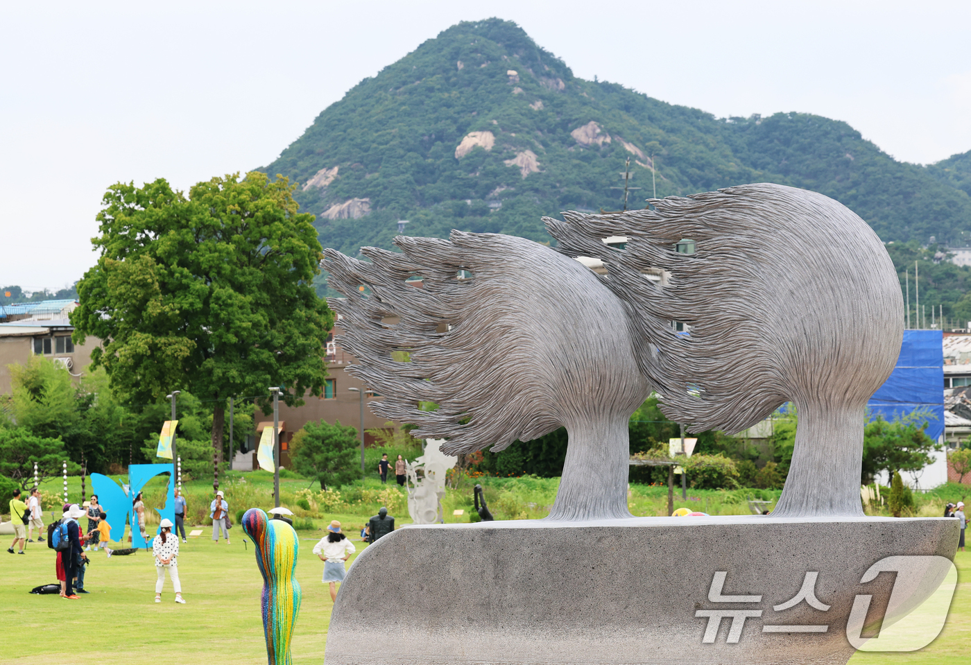 (서울=뉴스1) 오대일 기자 = 30일 오후 서울 종로구 열린송현녹지광장을 찾은 시민들이 제3회 서울조각페스티벌 전시작을 감상하고 있다.‘예술의 도시, 산들바람 타고’를 주제로 열 …