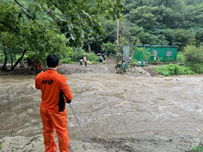 (화순=뉴스1) = 30일 오후 전남광주 화순군 한천면 죽헌로 일대에서 호우로 범람한 계곡물에 도로가 침수되자 소방대원들이 고립된 주민들을 구조하고 있다.(전남광주통합소방본부 제공 …