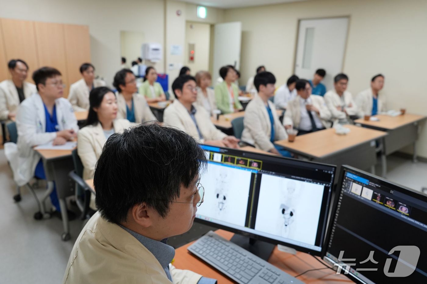 본문 이미지 - 서울성모병원 핵의학과의 하승균 교수가 전립선특이막항원 핵의학치료가 필요한 환자의 검사 영상을 지난 19일 다학제 회의 논의 안건으로 준비하고 있다. 약 20명의 비뇨기암 다학제-협진 의료진은 환자의 검사 영상을 회의실 스크린에서 함께 확인하며 향후 치료 방향을 논의했다.(가톨릭대 서울성모병원 제공)