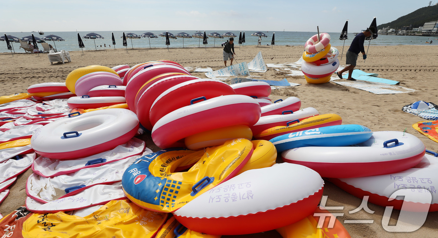 (부산=뉴스1) 윤일지 기자 = 31일 폐장을 앞둔 부산 해운대구 송정해수욕장에서 관계자들이 튜브 등 물놀이 용품을 정리하고 있다. 2026.8.31/뉴스1